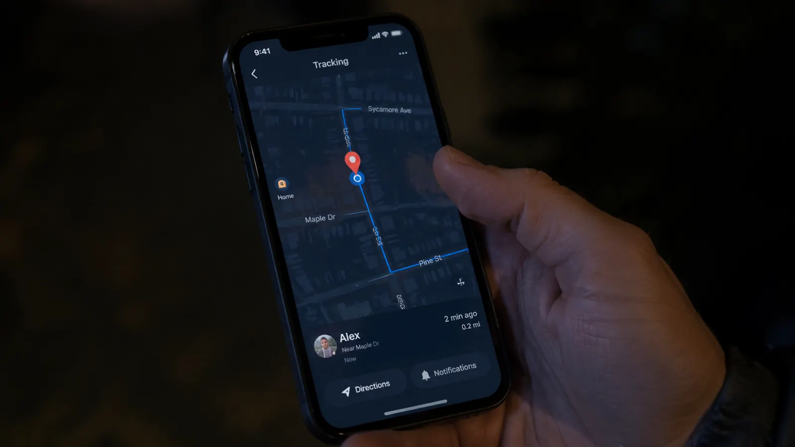 Smartphone screen showing a GPS map app with a dog location pin moving along a suburban street at night